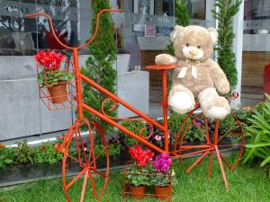 蒙蒂锡昂Vivas Hotel e Casa的一只泰迪熊坐在一辆橙色的自行车上,满是鲜花