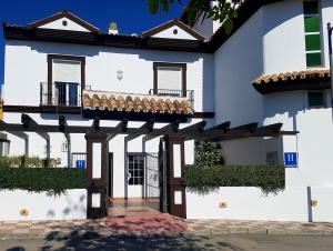 Fuensanta阿萨多阿尔本扎酒店的白色的房子,设有门廊和阳台