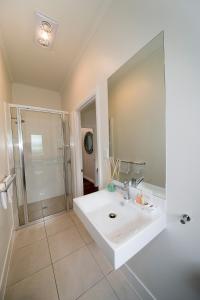 谭伯连山坦博林山度假屋的白色的浴室设有水槽和淋浴。