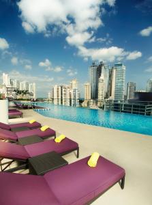 巴拿马城Megapolis Hotel Panama的建筑物屋顶上的一排紫色躺椅