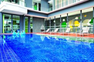 新加坡ST Residences Novena的大楼内带桌椅的大型游泳池