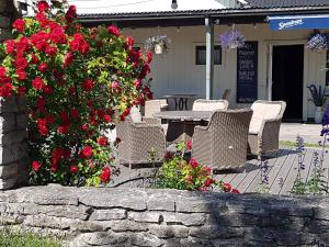 托弗塔Tofta Bed & Breakfast的庭院配有椅子和红色鲜花桌子