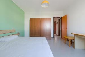托瑞帕利Appartamento Oasi by BarbarHouse的卧室配有一张白色大床和一张书桌