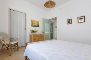 普罗斯西托角Serra degli Angeli by BarbarHouse的白色卧室配有床和椅子