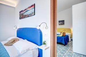 马萨鲁布朗斯奥勒姆乡村民宿的一间设有蓝色床头板的卧室和一张位于客房内的床