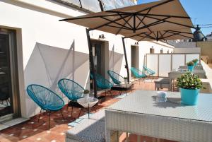 瓦伦西亚文奇莱斯酒店的一个带蓝色桌椅和遮阳伞的庭院