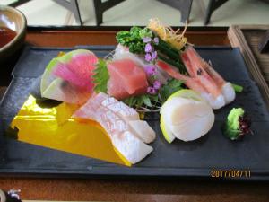 丰冈市米哈拉索日式旅馆的桌上的盘子,包括寿司和蔬菜