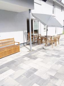 鲁斯特Pension Eichel的客房铺有瓷砖地板,配有长凳和遮阳伞。