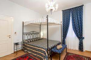 威尼斯丽都卡萨诺瓦别墅酒店的一间卧室配有一张天蓬床和吊灯。