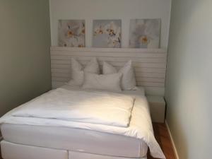 梅尔克狮子公园公寓的一张带白色床单和白色枕头的床