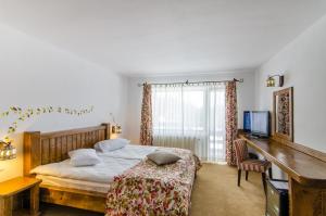 丰达塔Cheile Gradistei Fundata Resort的一间卧室配有一张床、一张书桌和一台电视
