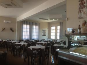 圣塔马利奈拉勒托里酒店的用餐室设有桌椅和窗户。