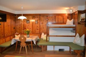 瓦尔道拉Ferienwohnung Pramstaller的客房设有一张桌子和一张双层床。