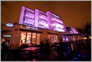 伯恩茅斯坎伯兰海洋休闲酒店的大楼一侧的紫色灯餐厅