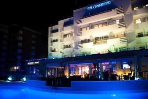 伯恩茅斯坎伯兰海洋休闲酒店的一座建筑,在晚上前方有一个游泳池