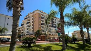 阿尔加罗沃Seaside romantic apartment的一条街道前方有棕榈树的高楼