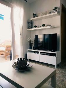 阿尔加罗沃Seaside romantic apartment的客厅配有平面电视和桌子。