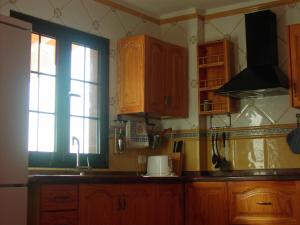 拉雷斯廷加Vivienda Vacacional La Roca的厨房配有木制橱柜、水槽和窗户。