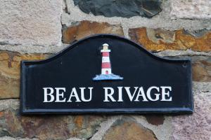 普卢阿Residence Beau Rivage Brehec的墙上的标牌,上面有灯塔