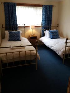 基尔马诺克House for Groups & Contractors Kilmarnock的带窗户的客房内的两张床