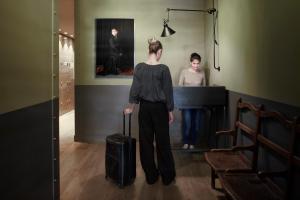 特拉维夫弗劳兰丁旅舍的站在钢琴前拿着手提箱的女人