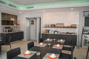 托尔博莱Hotel Aurora & Appartamenti的一间带桌椅的餐厅和一间厨房