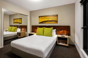 墨尔本Quest Docklands的酒店的客房 - 带两张带绿色枕头的床