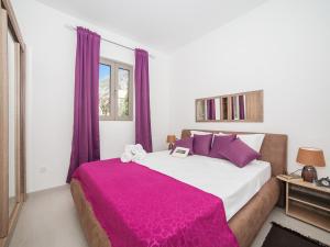 科托尔卡斯特罗公寓的一间卧室配有一张大床和紫色窗帘