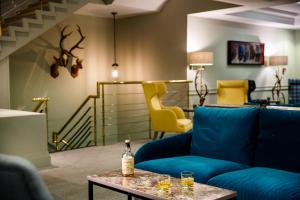 因弗内斯因弗内斯美居酒店的客厅配有蓝色的沙发和黄色的椅子