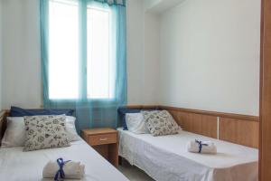 托里德欧索Residence La Poesia - Direzione Salento的客房内的两张床和毛巾