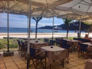 波罗斯Pantelis的一间带桌椅和海滩的餐厅