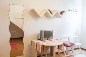 奥尔塔Casa de Hóspedes Porto Pim的客房设有一张桌子、一台电视和一张桌子。