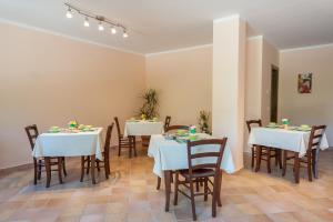 波利卡Il Melograno的一间用餐室,配有2张带白色桌布的桌子