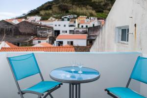 奥尔塔Casa de Hóspedes Porto Pim的美景阳台配有一张桌子和两把椅子