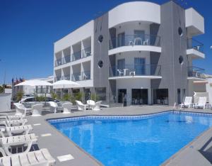 阿尔布费拉阿尔布费拉KR酒店的一座带游泳池和椅子的酒店和一座建筑