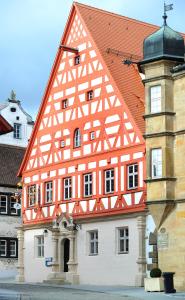 Wolframs-Eschenbach阿尔特沃格泰酒店的一座橙色和白色的建筑,设有钟楼
