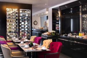 巴黎奥斯曼别墅酒店的一间带桌椅的餐厅和一间酒吧