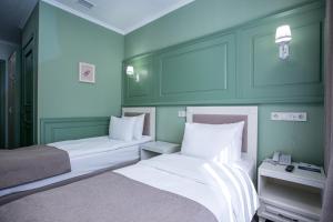 阿拉木图蓝宝石大酒店 的绿墙客房内的两张床