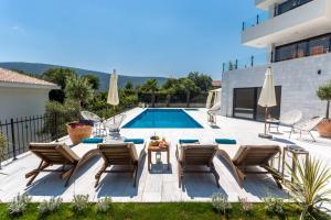 赫尔采格诺维White Olive Villa的别墅 - 带带椅子和桌子的游泳池