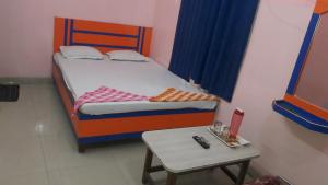 加雅Hotel Utsav & Marriage Hall的一间小卧室,配有一张床和一张桌子