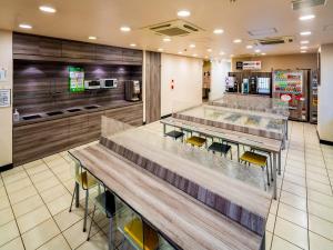 大阪新大阪东口超级酒店的一间设有桌椅的快餐店