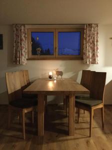 SibratsgfällApartment Nest的餐桌,带两把椅子和蜡烛