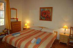El CedroCasa el Anden的一间卧室配有一张带蓝色拖鞋的床。