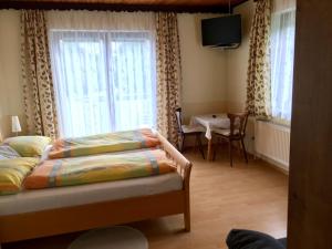 伯海姆基兴附近卡斯滕格沃斯维尔特宾馆的卧室配有床、桌子和窗户。