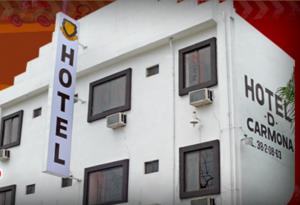 巴耶斯城狄卡莫纳酒店的白色的建筑,有窗户,上面有标志