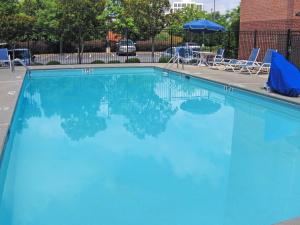 亚特兰大美国长住酒店 - 亚特兰大 - 维宁斯的一个带椅子和遮阳伞的大型蓝色游泳池