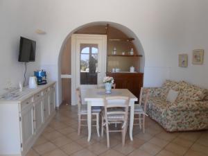 法萨诺B&B La Collina Degli Ulivi的厨房以及带桌子和沙发的客厅。