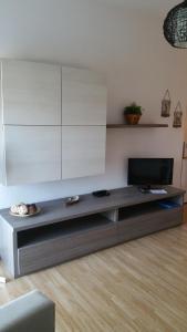 罗马辛尼塞塔埃斯特公寓的客厅配有餐桌上的平面电视