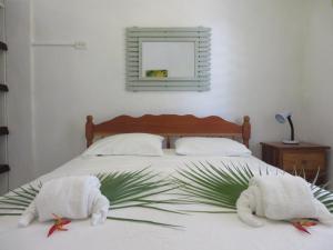 玛雅湾Simberts Apartments的一间卧室配有带毛巾和植物的床