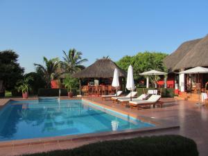 Tanji怀特宏丝酒店的度假村的游泳池,配有椅子和遮阳伞